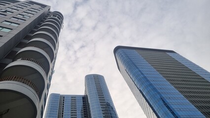 Modern tall building with unique design. Low angle view of abstract curve lines and sky. Geometric...