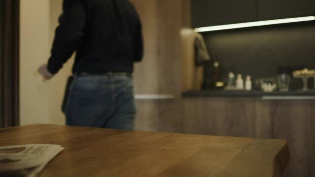 Unrecognizable man taking keys, travel mug and leaving for work