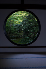 Traditional round window and garden of a Japanese temple