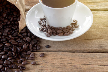 Hot coffee and coffee beans on wood table background