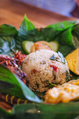 Nasi Liwet, Spicy steamed rice, Indonesian style with fried anchovies, chili, corn fritters, lemon basil or 