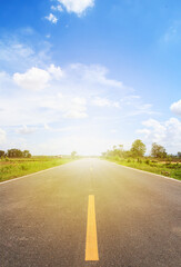 Concrete road in the countryside has a beautiful green rice field along the way.
