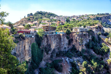 Fototapeta na wymiar Picturesque houses and restaurants stand on a rocky mountain cliff. Republic of Lebanon