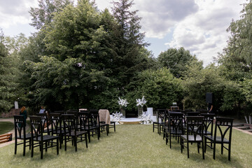 a beautiful arch for a wedding ceremony in a park with chairs