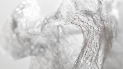 A closeup of a intricately designed wire frame sculpture with thin delicate wires crisscrossing and intersecting to create a dynamic and fluid structure. The sculpture appears