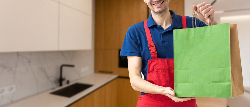 Young handsome man holding delivery paper bag