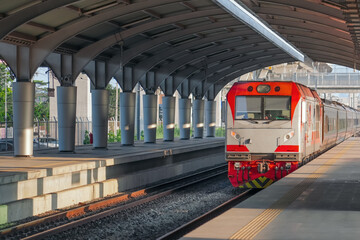 Long-distance train arrives at a transit passenger suburban station