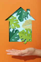 The house is cut out of paper with paper leaves