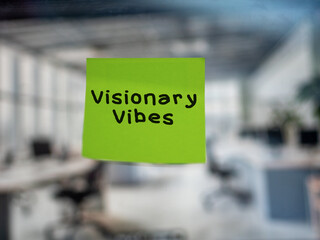 Post note on glass with 'Visionary Vibes'.