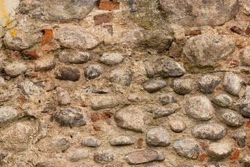 Grunge texture stone wall background. Rough old stone or rock texture of mountains. Coarse facing, grungy aged stonework city. Front antique decor house. General layout of stone masonry.