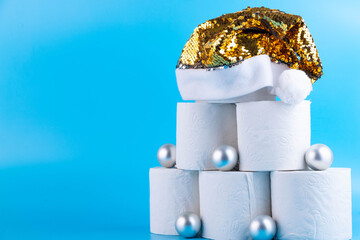 Christmas tree made of toilet paper rolls decorated with shiny balls and a golden santa claus hat...