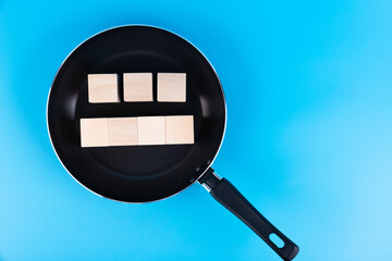 Concept of writing text on wooden blocks lying in a frying pan. Hot news.