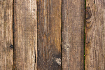 Wooden floor made of old boards with knots and cracks with rusty nails