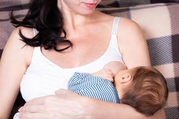 A woman breastfeeds her son. Breast-feeding