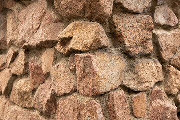 Grunge texture stone wall background. Rough old stone or rock texture of mountains. Coarse facing, grungy aged stonework city. Front antique decor house. General layout of stone masonry.