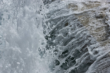 Jets of bubbling water of a waterfall close-up.