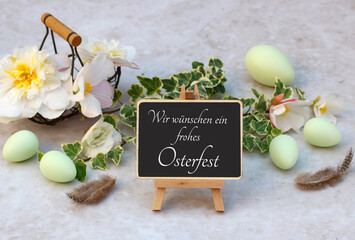 Grußkarte Frohe Ostern. Ein Strauß Blumen und Ostereier mit dem Text wir wünschen ein frohes...
