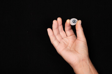 Cosmetic prosthesis of the human eye on a black background. Selective focus.