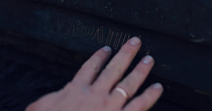 Close-up of a black, burnt piano and a man's hand. A burnt piano with the inscription Ukraine.