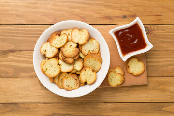 Spiced bruschette chips on wooden background, top view