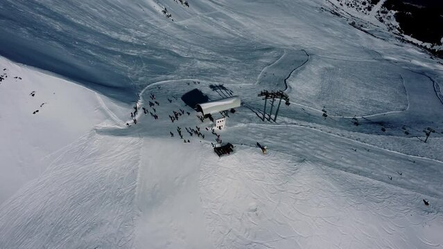 Top chairlift station Planseggbahn in Austria with people skiing, aerial