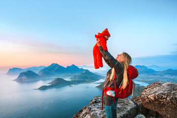 Mother hiking with baby outdoor family vacations in Norway travel in Lofoten islands active healthy...