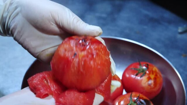 토마토에 칼집을 내어 불에 구워 껍질을 벗기는 모습