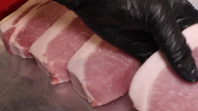 등심돈가스용 돼지고기 생고기를 칼로 두툼하게 써는 모습
