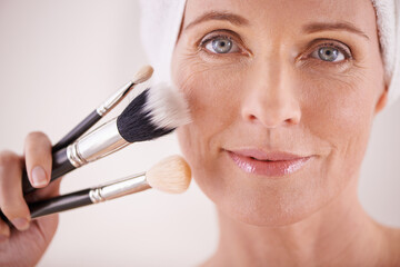 Brush, makeup and mature woman in portrait or studio for cosmetics, beauty and facial treatment....