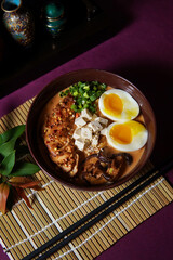 Ramen served in a bowl with egg, tofu, chicken breast, mushroom, sapporo, donkocheu, soup ramen, single serving, fine dining, Japanese cuisine, chives, food photography, restaurant menu
