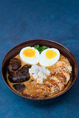 Ramen served in a bowl with egg, tofu, chicken breast, mushroom, sapporo, donkocheu, soup ramen, single serving, fine dining, Japanese cuisine, chives, food photography, restaurant menu