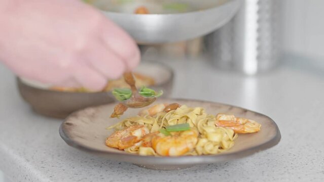 A close-up image capturing the moment as steaming shrimp pasta is being served on a rustic plate. The focus is on the perfectly cooked prawns and the appetizing noodles.