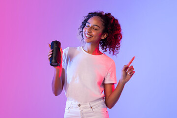Cheerful woman holding game controller and pen