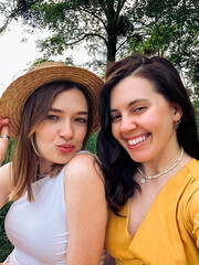selfie of two smiling young women outdoors in summer