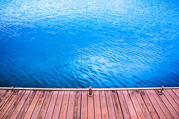 Wood plank for walk with water surface waves background