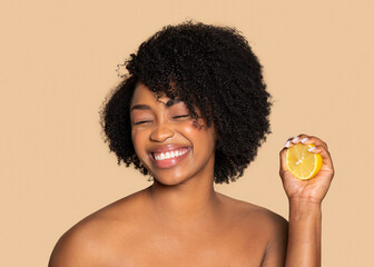Joyful black woman with lemon, natural beauty zest