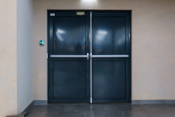 View of the closed door of the evacuation exit from the building during a fire or other cataclysm. Emergency fire exit from the building. Closed emergency exit door, for quick evacuation