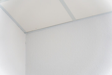 Parts of the ceiling decor in the corner, suspended ceiling made of white gypsum slabs. Modern...