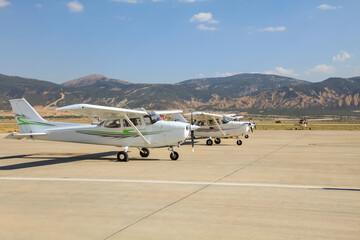 Small single propeller planes parked at the airport.