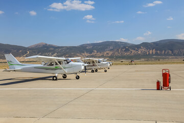 Small single propeller planes parked at the airport.