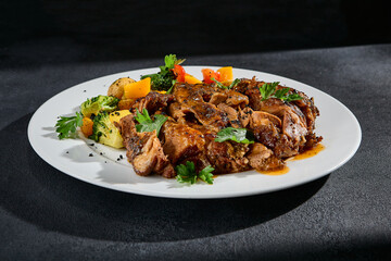 Beef brisket with roasted vegetables on a white plate