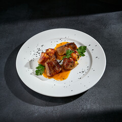 Beef tongue with roasted potatoes on a white plate