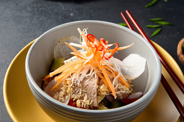 Beef with daikon and carrots in a stacked bowl setup on a textured table