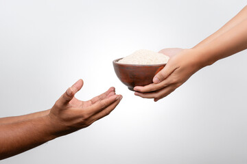 Closeup Hands giving bowl of rice for zakat fitrah. Concept of alms, food sharing and help each...