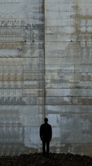 Man standing in front of a large concrete wall