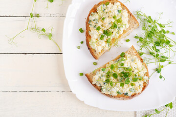 Delicious toast with pate boiled egg, cucumber and cream cheese on a white plate. Healthy eating,...
