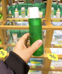 buying make up at cosmetics section in store. choosing cosmetics, perfumes, creams and shampoos