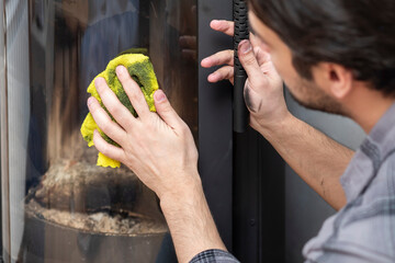 A man cleans a fireplace after the end of the heating season	