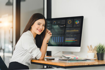 Fototapeta na wymiar A businesswoman or accountant using laptop to analyze financial investments and business and marketing growth on a data graph. The concepts of accounting, economics, and commercial analysis.