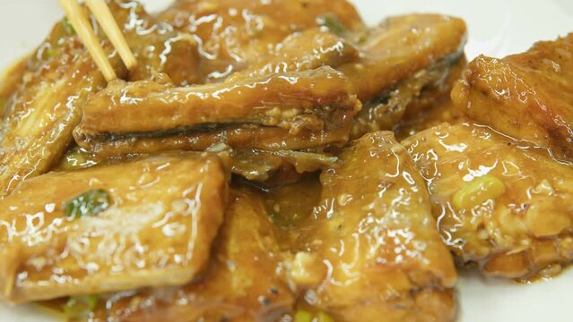 Graded UHD closeup shot of the delicious Chinese food. Stir-fried fish with thick sauce. Filmed as 6k RAW.